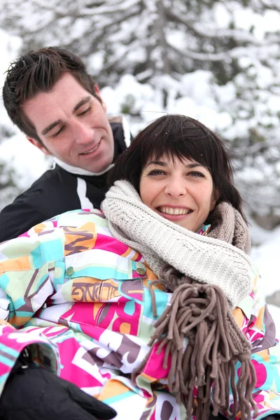 Flirtatious couple playing in the snow — Stock Photo, Image