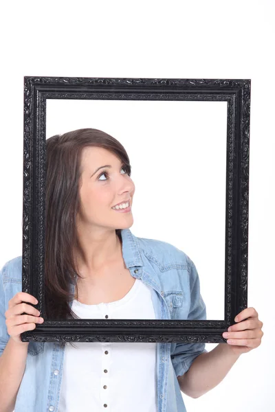 Woman stood holding empty picture frame — Stock Photo, Image