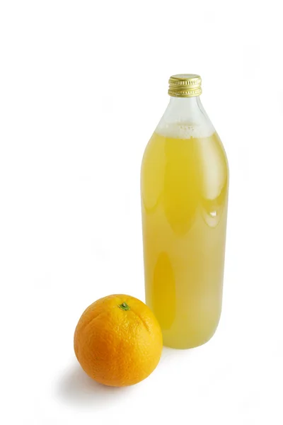 Апельсин и бутылка яблочного сока — стоковое фото