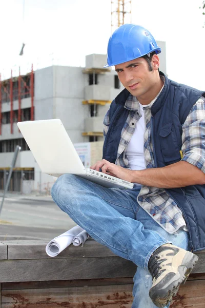 Bauarbeiter mit Laptop vor Ort — Stockfoto
