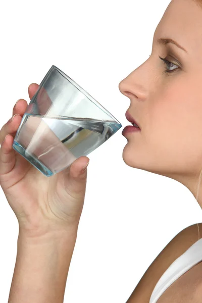 Νεαρή γυναίκα πίνει ένα ποτήρι νερό. — Φωτογραφία Αρχείου