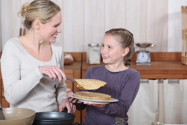 小さな女の子とお母さん約パンケーキ朝食を食べる — ストック写真