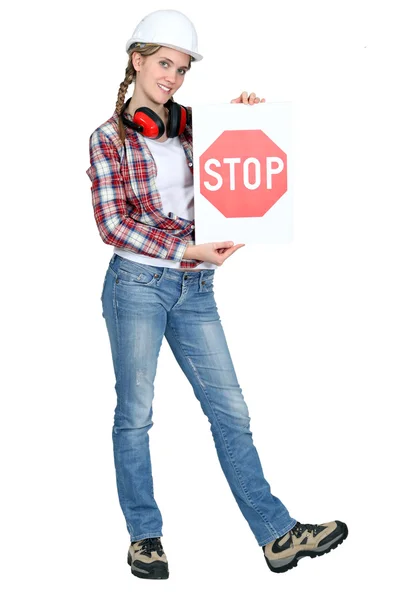 Female apprentice holding stop sign — Stock Photo, Image