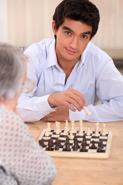 Бабушка играет в шахматы с внуком — стоковое фото