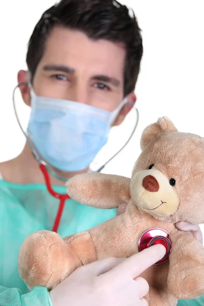 Doctor listening to teddy bear heartbeat — Stock Photo, Image