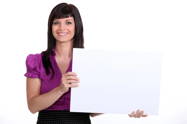 25 yaşında bir takım elbise ve beyaz bir panel gösterilen bir kadın — Stok fotoğraf