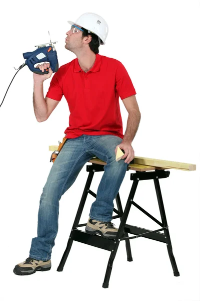 Man blowing on band-saw to cool it down — Stock Photo, Image