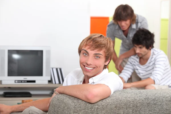Three young men about to watch television — Stock Photo, Image