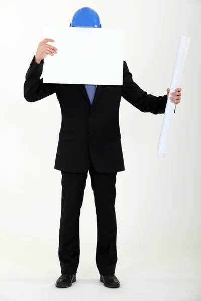 Unternehmer versteckt seinen Kopf hinter weißem Panel — Stockfoto
