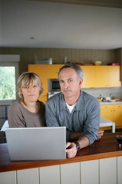 Пара с ноутбуком на кухне — стоковое фото