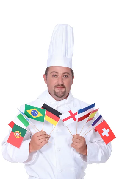 Šéfkuchař drží řadu národních vlajek — Stock fotografie