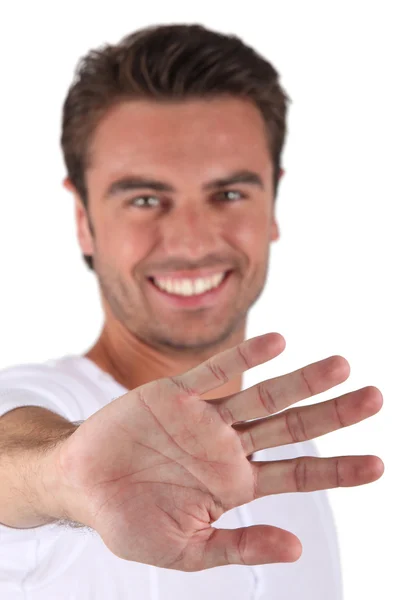 Uomo sorridente che mostra palmo — Foto Stock