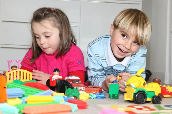 Brother and sister playing with toys — Stock Photo, Image