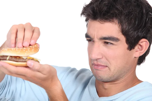 Mann hält Cheeseburger in der Hand — Stockfoto