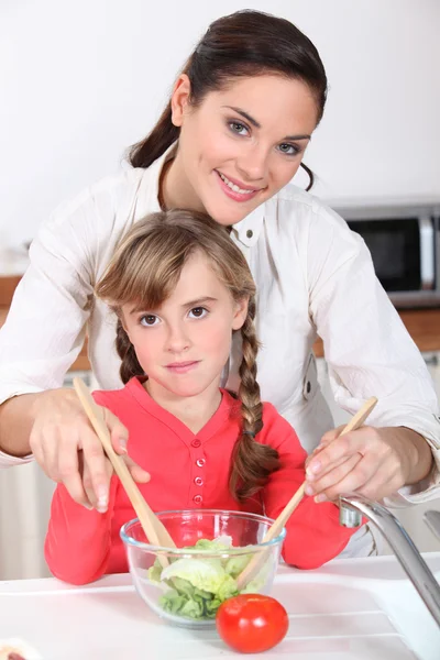 Matka a dcera připravují salát — Stock fotografie