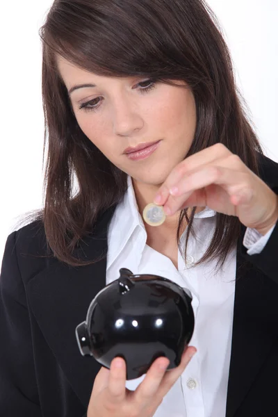 Young woman putting euros into a piggy bank — Stock Photo, Image
