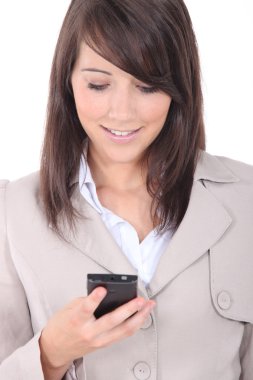 Young brunette sending message with mobile phone clipart