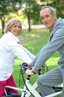 Senior couple on a bicycle clipart