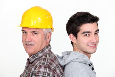 Tradesman standing back to back with his apprentice clipart