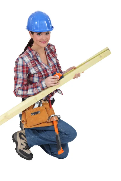 Carpinteiro fêmea medindo madeira — Fotografia de Stock