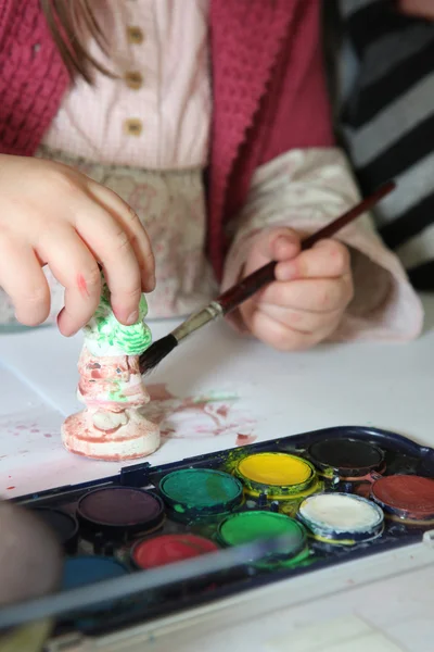 Child painting a plaster figurine — Stock Photo, Image