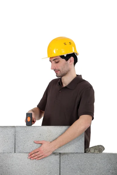 Mason usando martelo para ajustar a parede de tijolo — Fotografia de Stock