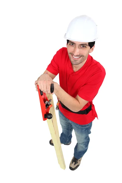 Craftsman holding a wooden board and a rasp — Stock Photo, Image