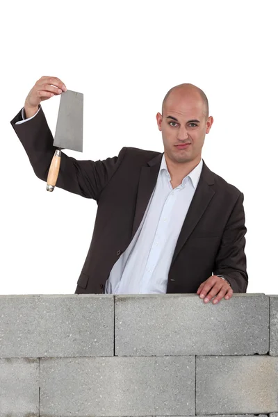 Office worker stood with trowel next to wall — Stock Photo, Image