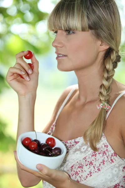Mulher loira comendo cerejas — Fotografia de Stock