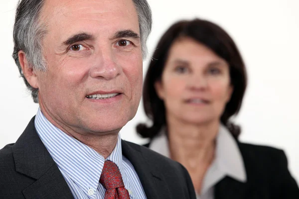 Oudere zakenman met een vrouw in de achtergrond — Stockfoto