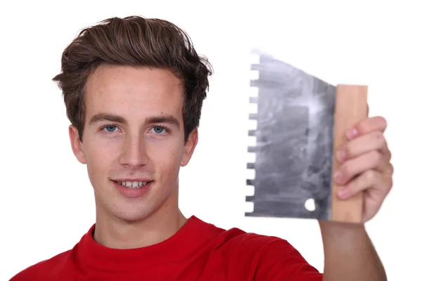 Giovane uomo con un pettine adesivo piastrelle — Foto Stock