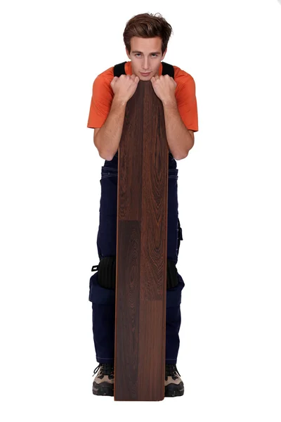 Uomo in piedi con tavola di pavimenti in laminato — Foto Stock