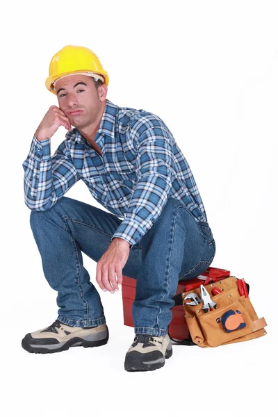 Aburrido constructor sentado en caja de herramientas — Foto de Stock
