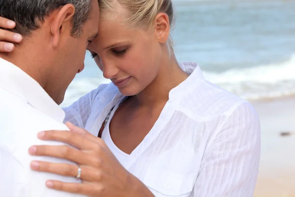 Affectionate couple dressed in white at the seaside — Stock Photo, Image