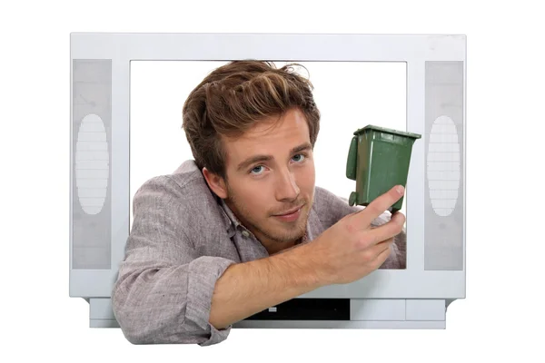 Чоловік тримає смітник рециркуляції всередині телевізора — стокове фото