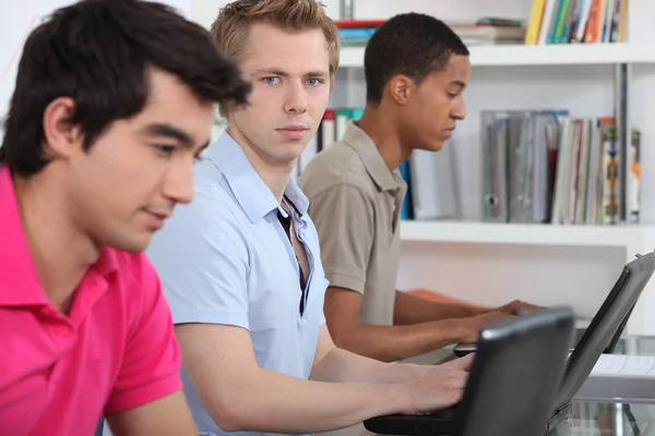 Three university students working on assignment — Stock Photo, Image