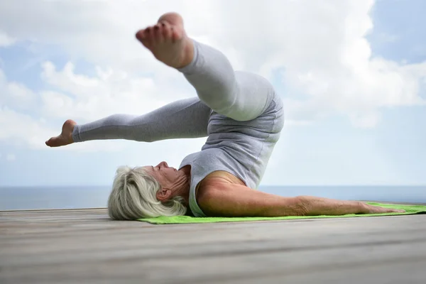 Kadın bir yoga pozisyon gerçekleştirme — Stok fotoğraf