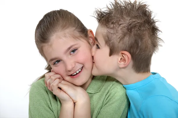 Мальчик целует девушку в щеку — стоковое фото