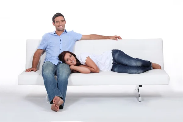 Couple on white sofa — Stock Photo, Image