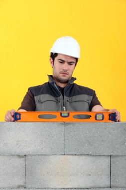 Bricklayer with a spirit level clipart