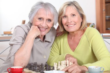 Mature women playing chess clipart