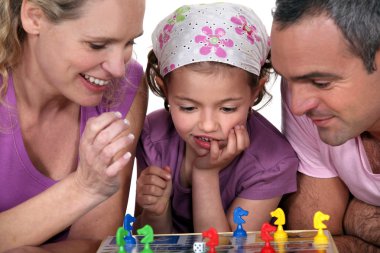 Young family playing a board game clipart