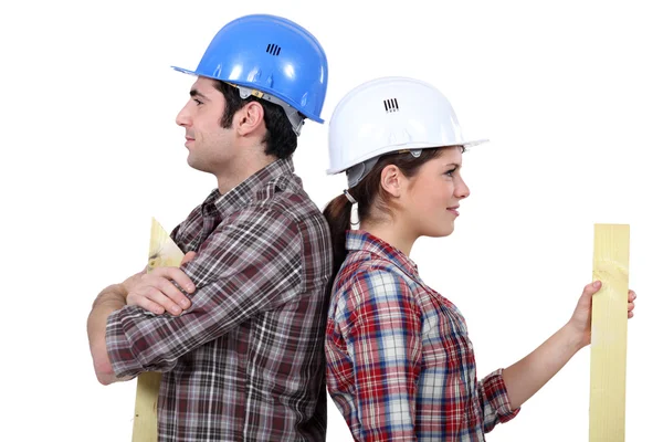 Manliga och kvinnliga byggare rygg mot rygg — Stockfoto