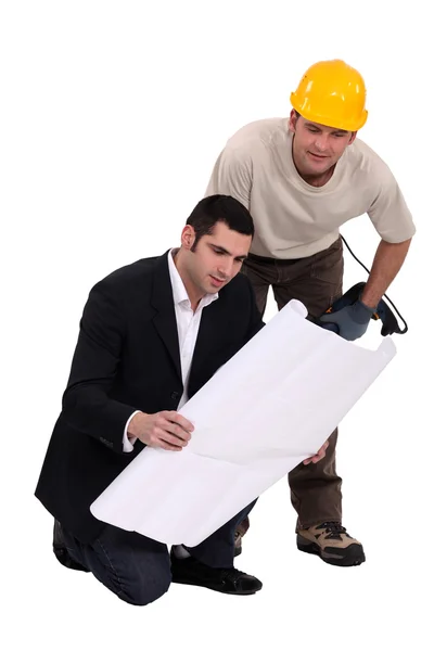 Consultoria do trabalhador da construção com um engenheiro sobre um desenho — Fotografia de Stock