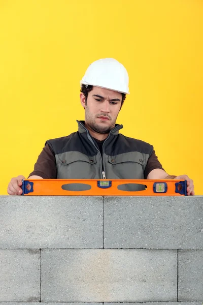 Bricklayer with a spirit level — Stock Photo, Image