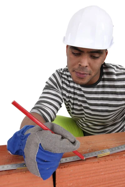 Bricklayer using a steel measure — Stock Photo, Image