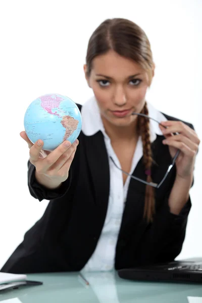 Frau hält Mini-Globus in die Höhe — Stockfoto