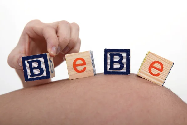 Stock image Pregnant woman with building blocks resting on belly