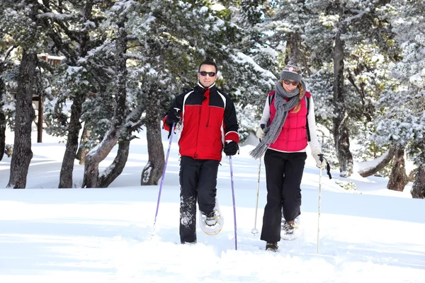 Couple walking in snowshoes — Stock Photo, Image