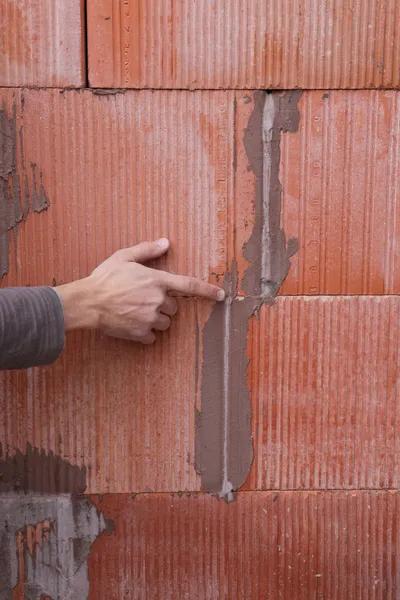 Man pointing out problem with wall — Stock Photo, Image